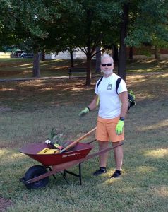 Doug at the park pushing a wheelbarrow.